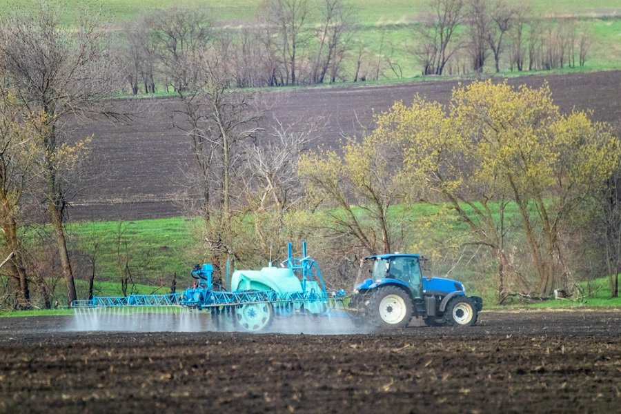 Tractor spraying herbicide on field